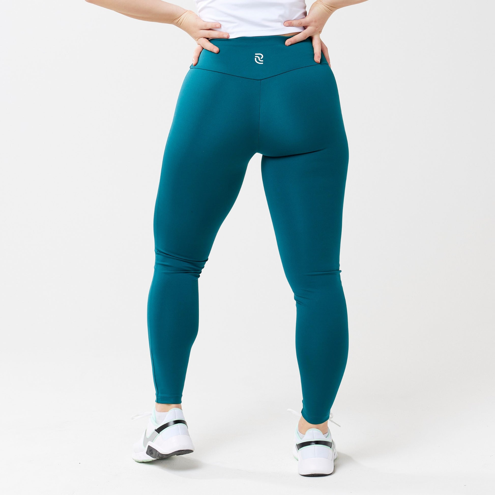 Plus model wearing rich teal leggings for use in active lifestyles as well as casual living.